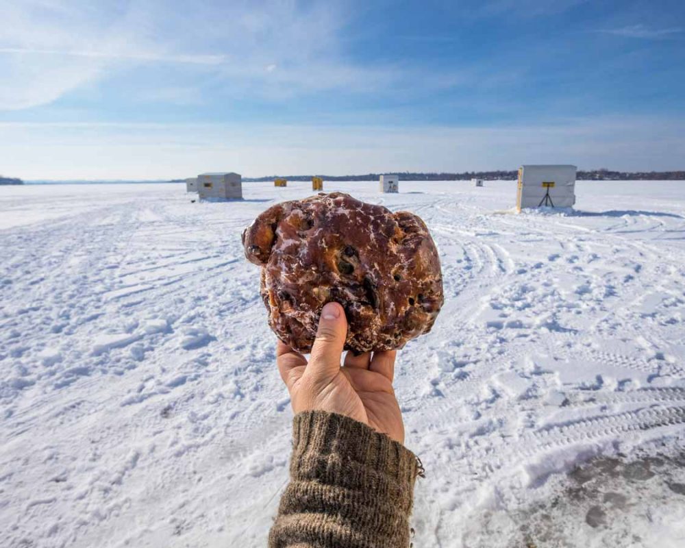 Hand holding giant Hanks Pastries Apple Fritter in Port Perry Ontario