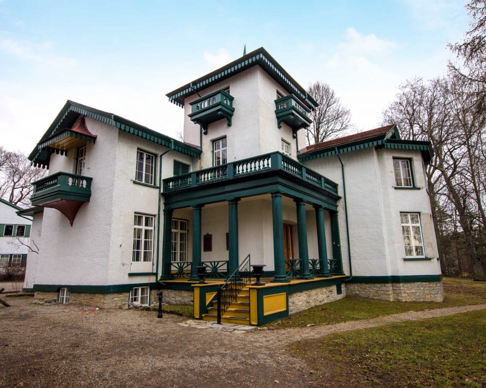 Historic white house with green trim on a sprawling lawn