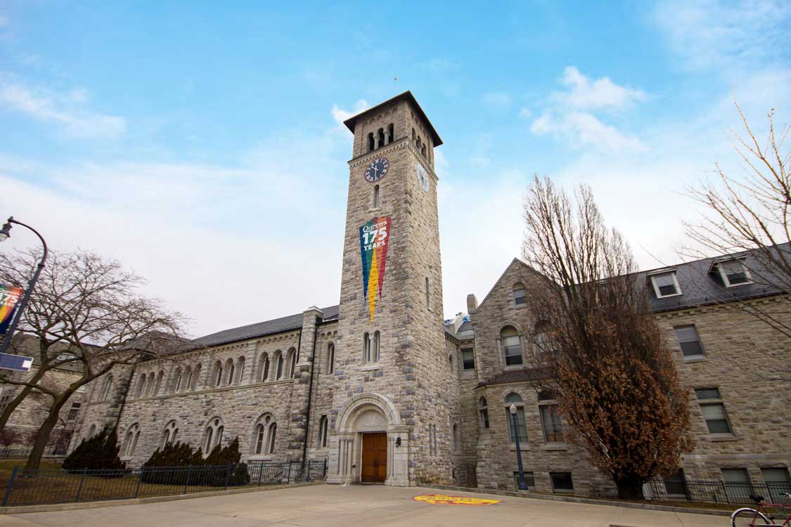 Tower of a university library against a blue sky with a rainbow flag hanging