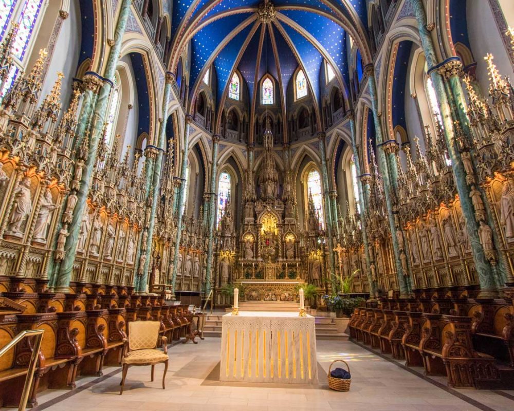 Dramatic interior of an Ottawa cathedral with candles and a bright blue ceiling