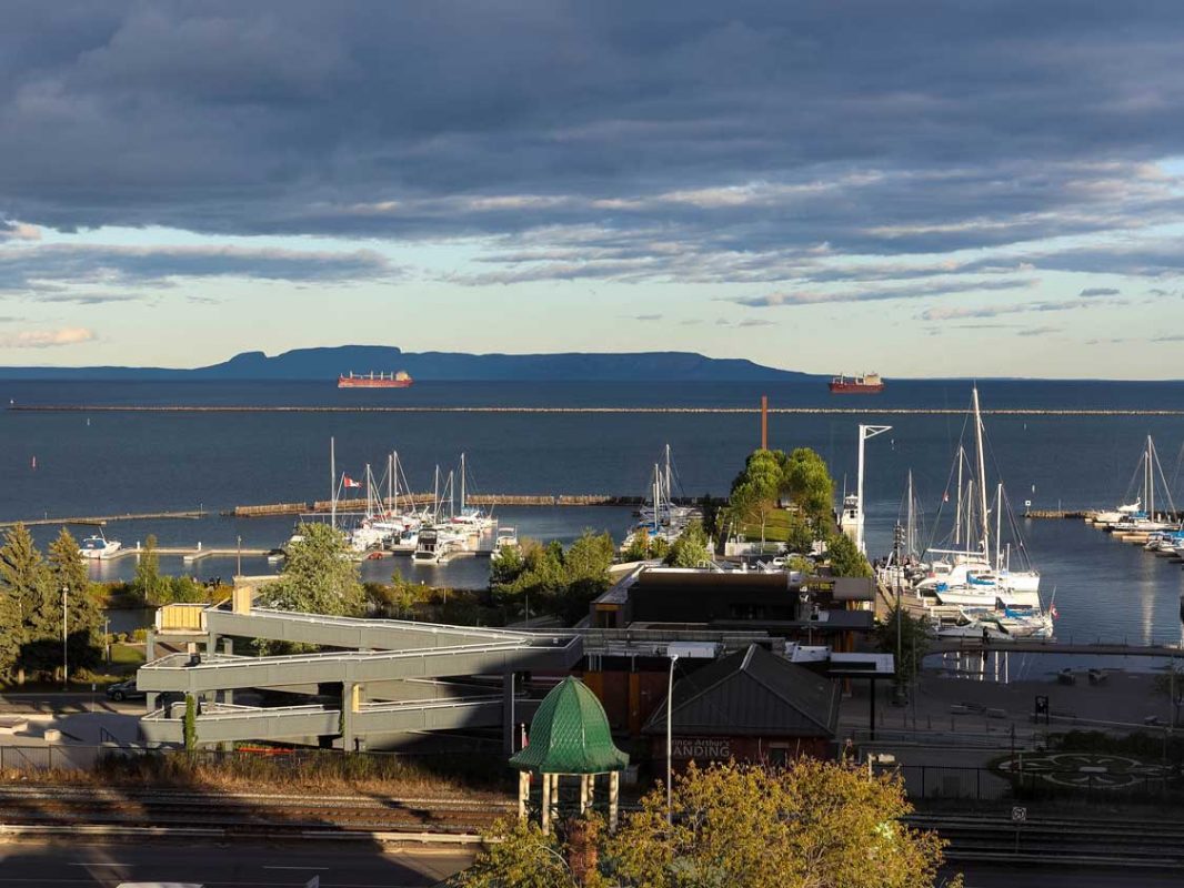 A northern Ontario marina with shipping boats and a large hill shaped like a sleeping giant