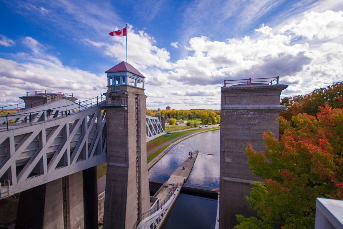 A Canadian flag flies at the top of of a stone lift lock in Peterborough Ontario