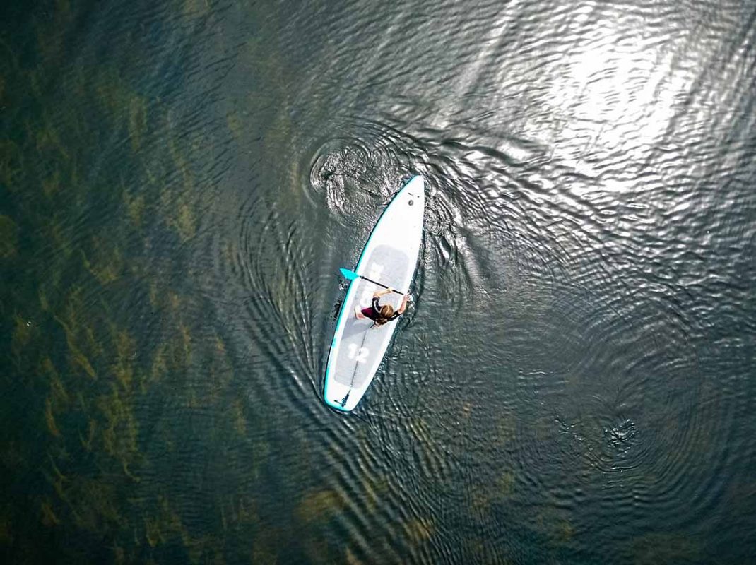 A young girl stand up paddleboarding on the Grand River in Brantford, Ontario