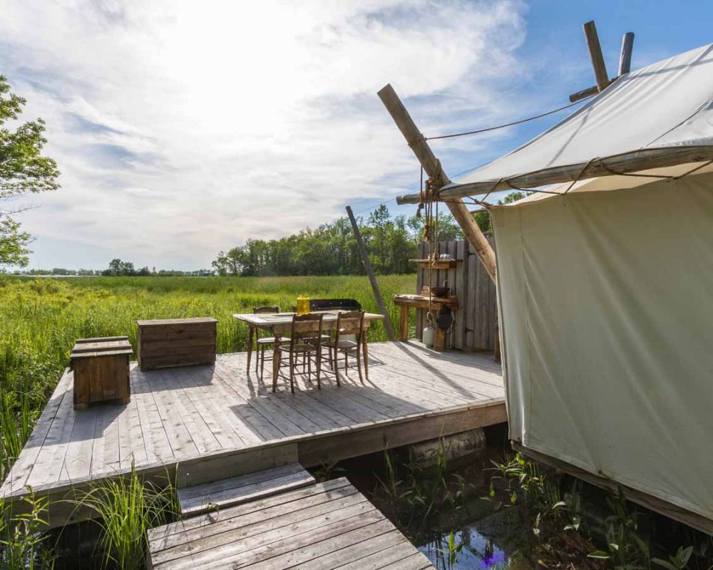 Prospector tent with a deck next to a lake in Prince Edward County