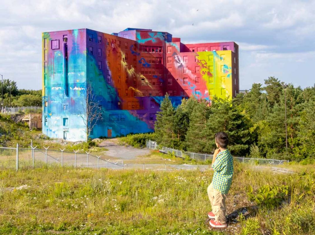 Boy standing in front of a huge mural in Sudbury