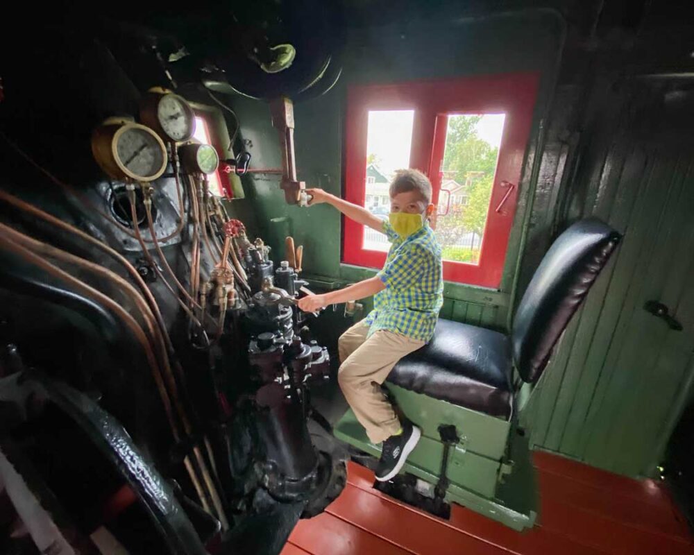 A boy plays in a locomotive at the Sudbury train museum