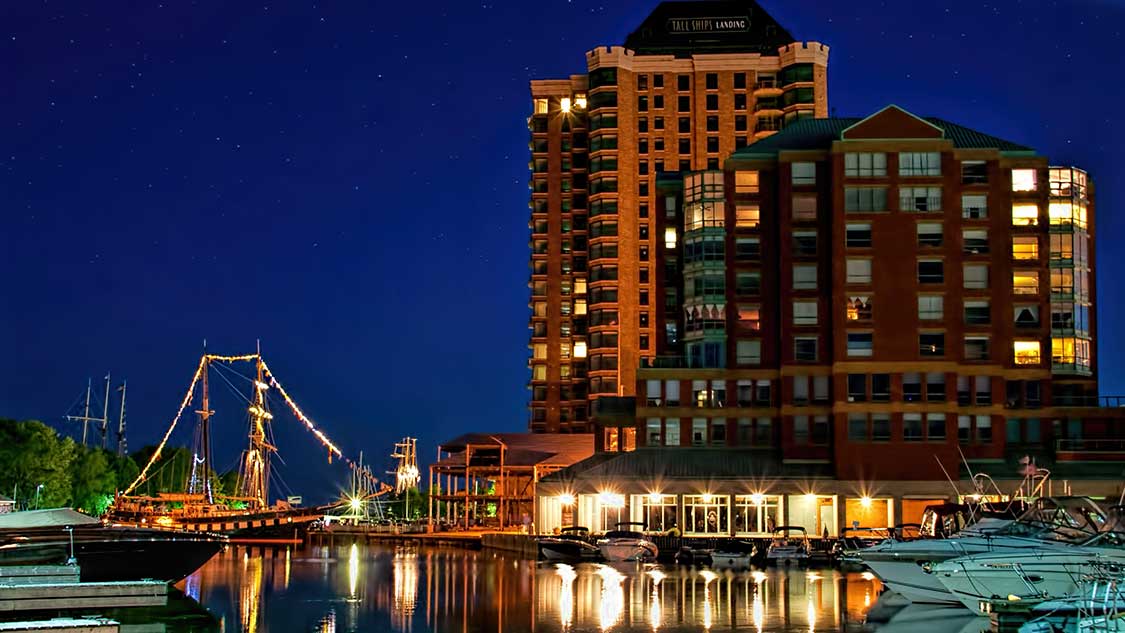 Boats with twinkling lights light up Tall Ships Landing harbour among things to do in Brockville, Ontario