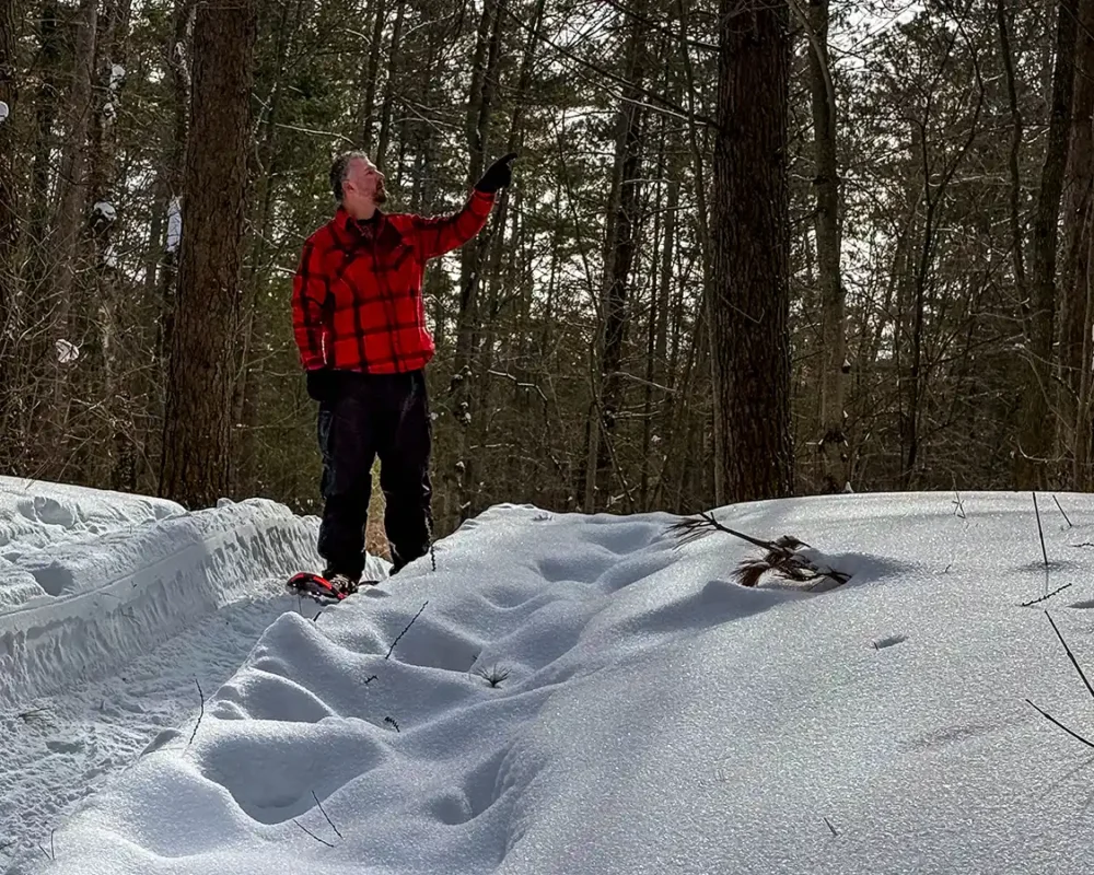 Man in a red plaid jacket snowshoeing along the Trans Canada Trail near Point Pelee National Park